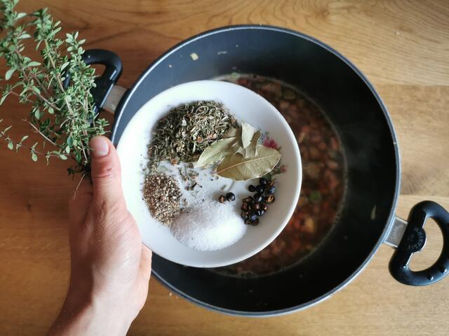Anschließend wird mit Rotwein und Suppe aufgegossen und die Gewürze werden hinzugegeben. | Foto: Katrin Ebetshuber