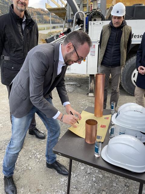 Bgm. Geir unterschreibt auf der Urkunde für die Zeitkapsel.