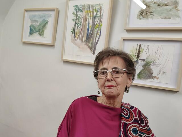 Christine Pantak posiert vor Aquarellwerken ihrer verstorbenen Freundin Edeltraud Brandl. | Foto: Tobias Graf