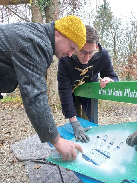 Stadtrat Thomas Rammerstorfer sprüht mit Unterstützung von Stadtrat Stefan Ganzert die Parkbank an. | Foto: StoP Wels