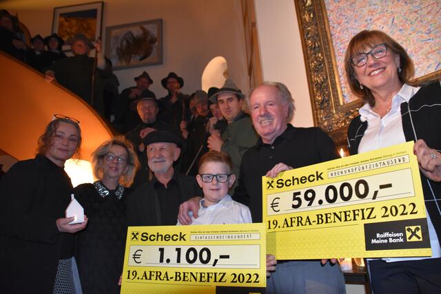 Umrahmt von den Anklöpflern überreichten Annaliese und Günther Stecher den Erlös in Höhe von 59.000 € aus dem Verkauf der Lithografien nach der Vorlage von Erwin Reheis (3.v.l) an die Vertreterinnen der Tiroler Frauenorganisationen, Gabi Plattner (li., Geschäftsführerin im Tiroler Frauenhaus) und Anneliese Junker (re., Obfrau vom Verein „Frauen helfen Frauen“). Auch Stecher-Enkel Julian (9) hat mit seinem Bild einen zusätzlichen Erlös von 1.100 Euro eingebracht.
