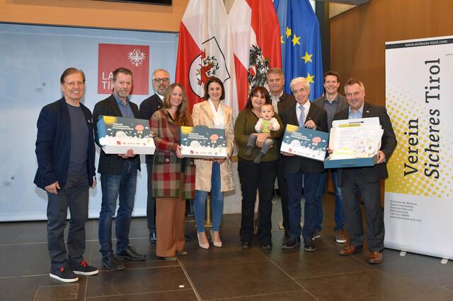 Bei der Präsentation der Tiroler Kleinkindersicherheitsbox im Landhaus: Karl Mark (Präsident Verein Sicheres Tirol), Alois Rathgeb (Geschäftsführer Gemnova), Horst Endruweit (Verein Sicheres Tirol), Birgit Pöltl-Zorn (Gebietsmanagerin Region West, DM Drogeriemarkt), LR Astrid Mair, Familie Höfer aus Schönberg, die die Kindersicherheitsbox erhalten hat, Franz Hauser (Vizepräsident Tiroler Gemeindeverband), Hermann Steixner (Bgm. Gemeinde Schönberg), Andreas Darnhofer (Geschützte Werkstätte Vomp) und Martin Reiter (Marketingleiter Tiroler Versicherung) (v. li.). | Foto: Land Tirol/Brandhuber