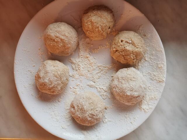 Aus der Masse mit einem Esslöffel portionsweise Teig entnehmen und mit bemehlten Händen zu Knödel formen.  | Foto: Katrin Ebetshuber