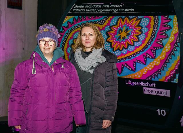 Künstlerin Patricia Hütter (l.) freut sich mit Elisabeth Rapp (Verband Druck Medien), dass ihr Motiv die Kabine der Rosskarbahn in Gurgl ziert. | Foto: Ötztal Tourismus/Jochen Müller