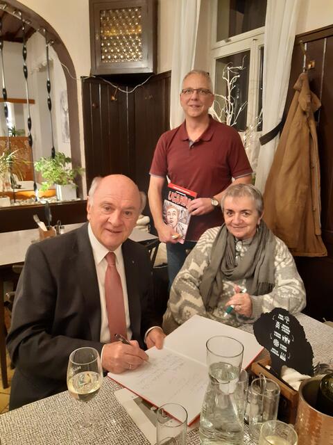 Eine Widmung vom ehemaligen Landeshauptmann, flankiert von Buchhändler Hans Sterzinger.