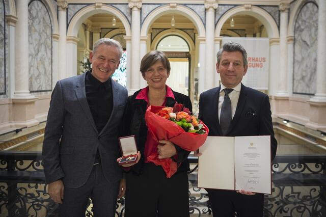 Corinne Eckenstein, künstlerische Leiterin Dschungel Wien, freut sich über das Ehrenkreuz der Republik Österreich. Links an ihrer Seite: Joachim Schloemer, Laudator und ehemaliger Intendant Festspielhaus St. Pölten, sowie rechts Jürgen Meindl, Leiter der Sektion Kunst und Kultur im Bundeskanzleramt. | Foto: HBF/BMKÖS/Kulec
