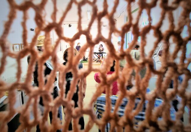 Blich durch die Arbeit "Verstrickte Zeit" von Marlies Liekfeld-Rapetti auf die Bühne mit Galvin's Garden im Kunstbahnhof Wörthersee | Foto: Marcel Ambrusch