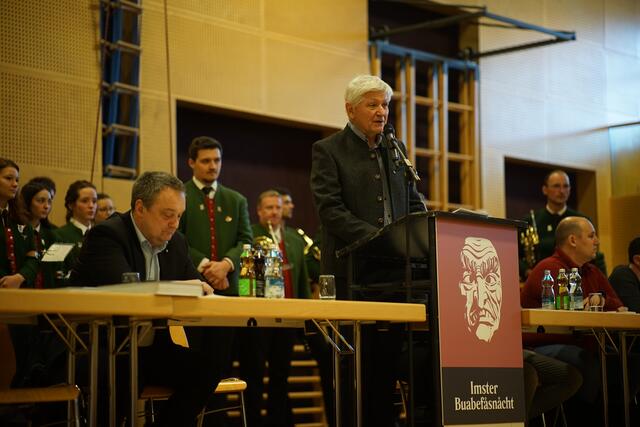 Fåsnåchtsobmann Uli Gstrein am Podium vor der alles entscheidenden Frage: „Söll mer huire wieder in d’Fåsnåcht giah?“ | Foto: Matt