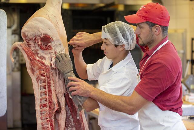 Landwirtschaftliche Fachschule Winklhof, LFS, Salzburg, Österreich, Fachrichtung Betriebs- und Haushaltsmanagement, Landwirtschaft und Produktveredelung, Fleischerei, Metzgerei, Fleischhauer, Fachpersonal, Fachkraft, Metzger, Fleischer, Lebensmittel, fachgerechtes zerlegen einer Schweinehälfte, Hygiene, Hygienevorschriften, im Bild li: Johannes Struber, Peter Gschaider Lehrer,  | Foto: Land Salzburg / Susi Berger - Camera Suspicta
