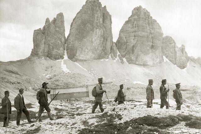Innehalten für das mythosstiftende Foto: Der am 4. Juli 1915 am Paternkofel gefallene und von den Italienern bestattete, berühmte Sextener Bergführer, Drei-Zinnen-Hüttenwirt und Standschütze Sepp Innerkofler wird am 27. August 1918 am Paternkofel enterdigt, in einen hochgebrachten Sarg gelegt und an den Zinnen vorbei ins heimatliche Tal gebracht. | Foto: © Anton Trixl; Sammlung Werkmeister Anton Trixl – TAP