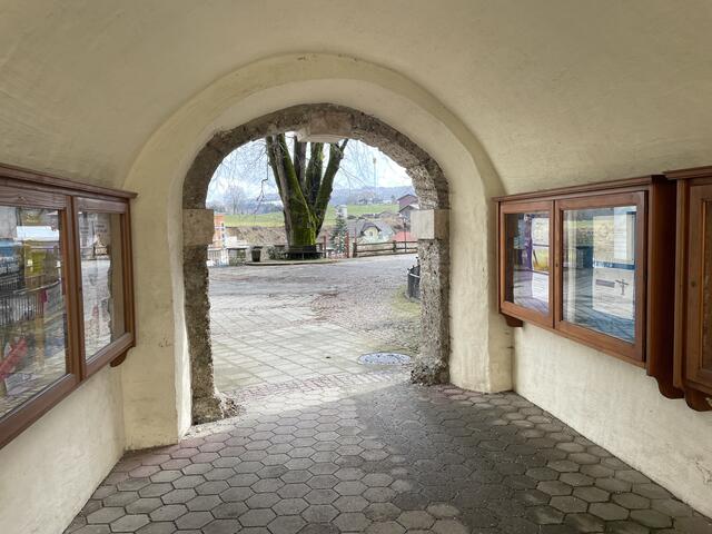 Wer den Schanzwall abgehen will, muss durch den Torbogen des Schanzhauses schreiten. Ein an der Pfaarkirche angebrachtes Schild leitet auf die kurze Rundwanderung.  | Foto: sm