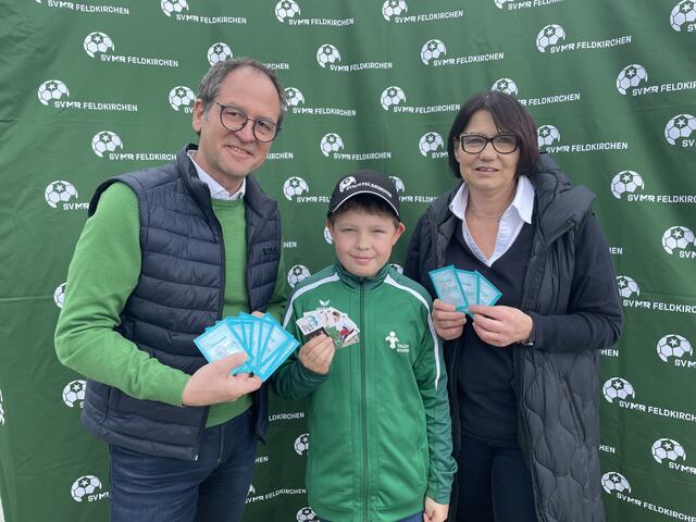 "Hol auch du dir deine SV M&amp;R-Kicker-Sticker" lautete der Slogan bei der Präsentation des neuen SV M&amp;R Feldkirchen-Sticker-Albums. Ingrid Maier und Gerhard Schreilechner mit einem jungen Stickerfan. | Foto: RegionalMedien