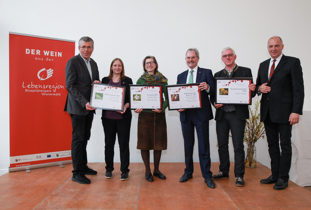 Martin Schuster, Nina Abrahamczik (1. und 2.v.l.), NÖ Landtagspräsident Karl Wilfing, Biosphärenpark-Direktor Andreas Weiß und Bezirkshauptmann von Mödling Philipp Enzinger (alle drei rechts außen) gratulieren den Preisträgern aus dem Raum Mödling (Mitte): Weinbau Barbach zum Sieg in der Kategorie Perl- und Schaumwein und Weißwein Klassik und zum Top-Weinbaubetrieb und Wein und Heuriger Pferschy-Seper zum Sieg in der Kategorie Weißwein Reserve (nicht im Bild). | Foto: BPWW/F. Spielauer