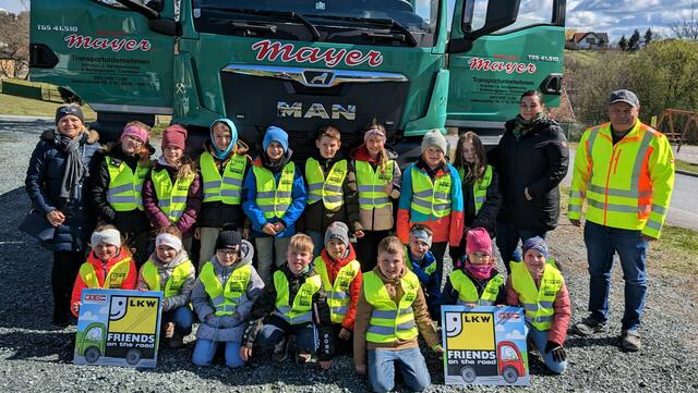 Direktorin Roswitha Karner, Teamlehrerin Verena Pahr und Lkw-Lenker Werner Roth (v. l.) mit den Kindern der Volksschule Aschau.  | Foto: WKB