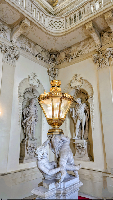 Stiegenaufgang mit prachtvollen Skulpturen. Die Lampen sind ein Blickfang