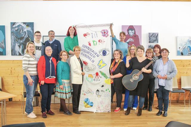 Starke Frauen - und zwei engagierte Männer - im Haus der Erinnerung mit der im Workshop kreierten Fahne. | Foto: Eckhart Herbe