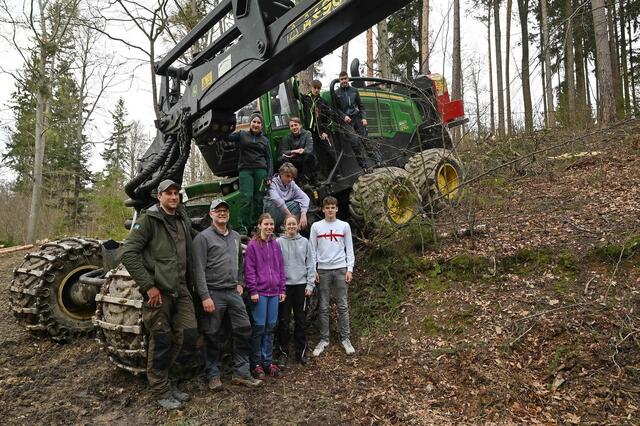 Geschäftsführer Stefan Mayerhofer (links) und Forstunternehmer Friedrich Handler (2.v.l.) mit den Schülerinnen und Schülern vor dem Harvester  | Foto: Jürgen Mück 