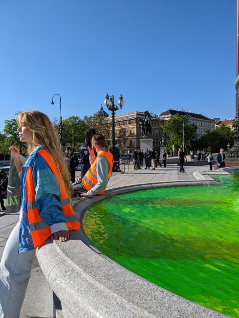 Die Aktivistinnen und Aktivisten betonen, dass die Farbe im Brunnen Uranin sei. Diese sei ungiftig und für die Umwelt unbedenklich. Der Farbeffekt zerfällt durch UV-Licht binnen weniger Stunden. Der Brunnen werde dadurch nicht beschädigt. | Foto: Letzte Generation Österreich