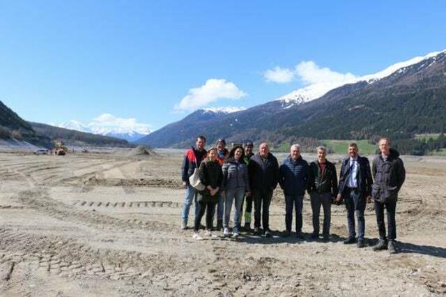 Lokalaugenschein im ausgetrockneten Becken des Reschensees: Amtsdirektor Strimmer und Mobilitätslandsrat Alfreider (1.u.2.v.r.) mit den Vertretungen der Gemeinde Graun und der Baufirmen. | Foto: LPA/Patrick Thaler