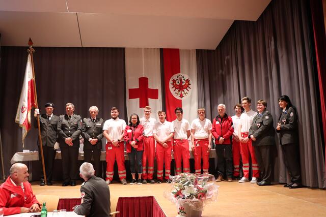 Feierliche Angelobung: RK-Bezirksstellenleiter Christian Klimmer, RK-Tirol Präsident Günther Ennemoser und Freiwilligenvertreterin Eva-Maria Errath mit den neuen aktiven Mitgliedern.  | Foto: Othmar Kolp