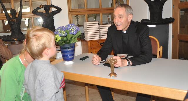 Kurienerzbischof Georg Gänswein nahbar: Buchsignieren und nette Unterhaltung mit dem kleinen Paul. | Foto: Kogler