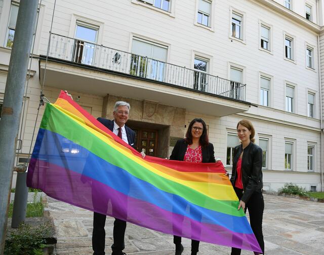 Hissen der Regenbogenfahne: Peter Kaiser, Sara Schaar und Leiterin der Gleichbehandlungsstelle Kaernten Susanne Ebner.
 | Foto: LPD/Krainz