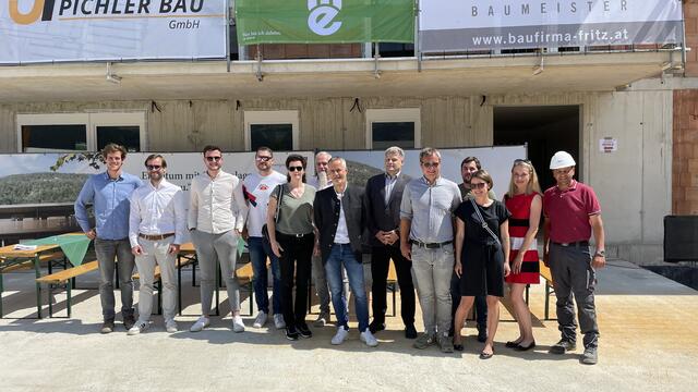 WE-Technikleiter Prok. Ing. Herwig Antretter (Mitte) mit den Beteiligten auf dem Gruppenfoto, darunter Bauleiter DI Gerhard Schmid und Projektentwickler DI Thomas Sailer, Bürgermeister Martin Schwaninger, DI (FH) Johann Pichler/JP Pichler Bau GmbH.,  Generalunternehmer mit Mitarbeiter:innen und Polier Bernhard Häfele (re.), DI Belinda Döring/ Architekturhalle-ZT KEG, ausführendes Planungsbüro.