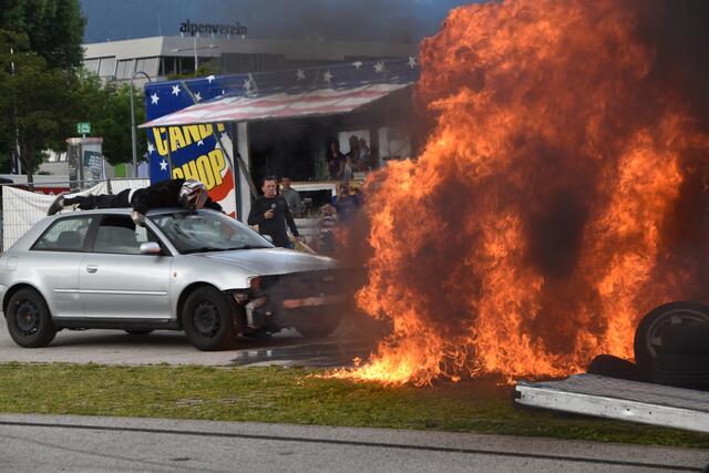 Ein Stuntman auf einem Autodach rast durch eine brennende Feuerwand. | Foto: Kendlbacher