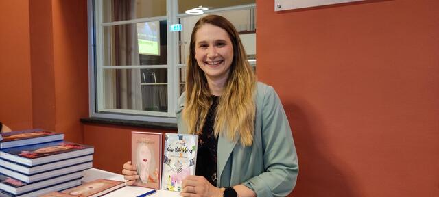 Poetry Slammerin Agnes Maier mit ihren Büchern zur persönlichen Widmung