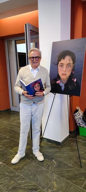 Folke Tegetthoff mit seinem Buch "Der Augenblick der Kinder", wo er sich links und rechts von einem Portrait fragt, was das Leben darum so spielt