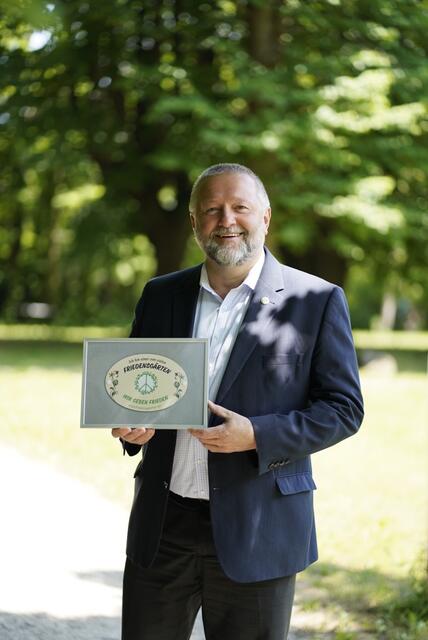 Friedrich Prassl, seit 2018 Direktor des Kardinal-König-Hauses, mit der Friedensgarten-Plakette.  | Foto: Thomas Werchota