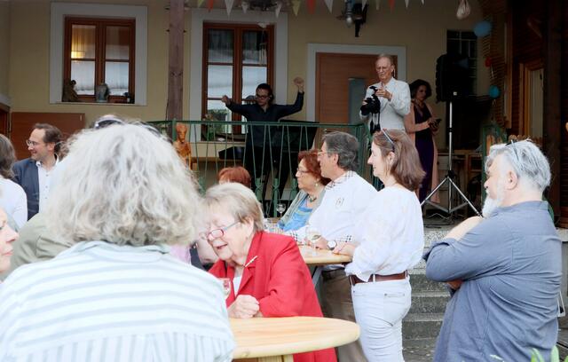 Gut besuchte Vernissage. Links hinten im Foto: Andreas Minnich, rechts hinten auf der Bühne und mit Kamera: Oskar Schillhart, Obmann des Fotoclubs Langenzersdorf, rechts dahinter: Daniela Krammer, Musikerin des Abends | Foto: Ingrid Seifert