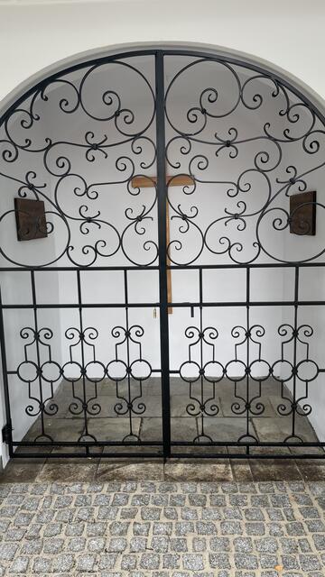 Das neue Schmiedeeisentor schaut nicht nur schön aus, sonder es schützt auch vor Vandalenakte, die in den letzten Jahren die Zerstörung der Wegkapelle verursacht haben.