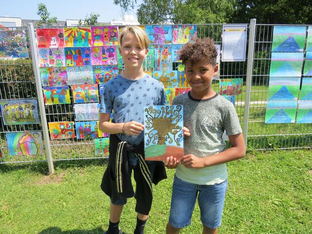 Moritz und Vincent sind stolz auf die vielen Bilder der Zaunausstellung.