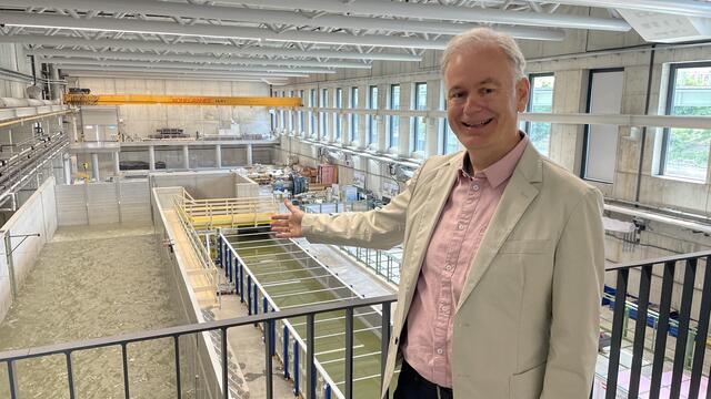 Initiator und Projektleiter Helmut Habersack der Boku Wien vor dem Herzstück des Wasserbaulabors, dem Forschungsgerinne "Big Fume". | Foto: Kathrin Klemm