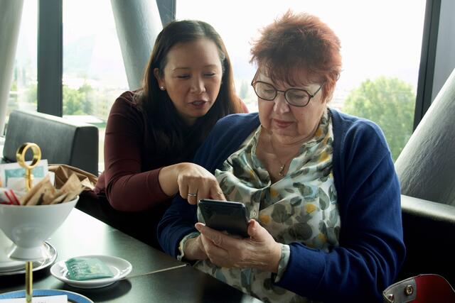 Die Freiwillige Jennifer Mai Van-Hametner und die Seniorin Christine Bejvl üben gemeinsam am Smartphone. | Foto: Petra Huber