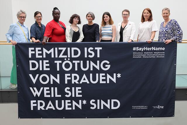 Von links: Gitti Vasicek und Tina Frank, beide Kunstuniversität Linz, Frauenbeauftragte Abena Carty-Pinner, Rebekka Hochreiter (3. Platz), Oona Valarie Serbest (1. Platz) und Leonie Kaltenegger (2. Platz) sowie Frauenstadträtin Eva Schobesberger, Personaldirektorin Brigitta Schmidsberger und Eva Schuh, Geschäftsführerin Gewaltschutzzentrum OÖ, mit dem über drei Meter großen Banner. | Foto: Stadt Linz