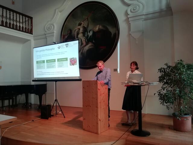 Christian Vötter und Susanna Vötter-Dankl mit ihren plakativen Kohr-Ideen vor dem Gemälde eines gleichfalls berühmten Johann Michael Rottmayrs mit dem Bild der Allegorie des Blicks in die Sterne.  | Foto: Sturm/Laufen