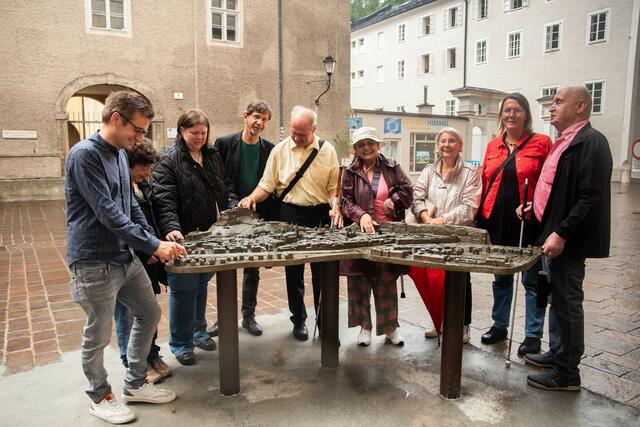 Das Tastmodell befindet sich in der Franziskanergasse, kurz vor den Dombögen
im Bild: Mitglieder des Behindertenbeirats vor dem Tastmodell | Foto: Stadt Salzburg/Rocio Escabosa