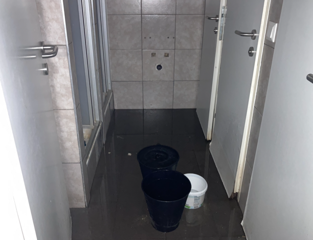 Der ganze Boden im gemeinsamen Badezimmer ist nass, von der Decke tropft es dauerhaft runter. Die Mieterschaft hat deswegen die Kübel aufgestellt, der Wasserschaden lässt sich aber dadurch nicht stoppen. | Foto: Ronja Reidinger
