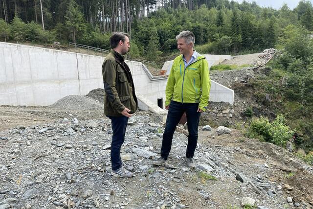 Im Bild Christoph Stöckl (Obmann der Wildbachgenossenschaft Grubingerbach) und Gebhard Neumayr (Gebietsbauleiter der WLV-Pinzgau) vor der errichteten Wildbach-Sperre beim Grubingerbach in Hollersbach. | Foto: Land Salzburg/Martin Wautischer