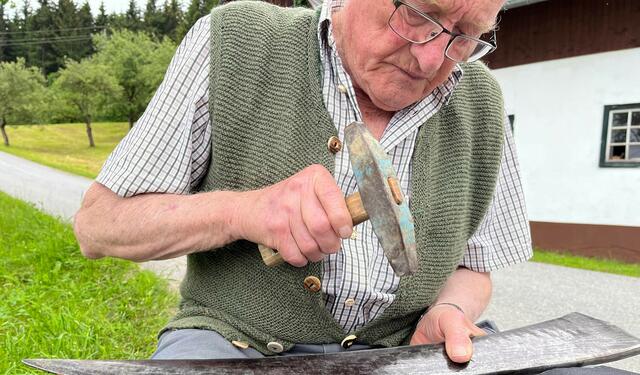 Altbauer Temmel beim Sensenschärfen. | Foto: RANFILM