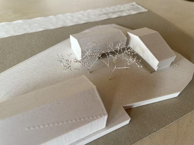 Ein Modell der neuen Anlage: Hinten die beiden Wohnobjekte, im Vordergrund das bestehende Bildungszentrum mit Volksschule und Kindergarten. | Foto: Reichel