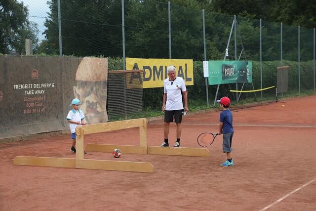 Beim Tenniscamp des ATUS Kalsdorf durften bereits Fünfjährige mitmachen. Heinz Käfer übt mit den Kindern beim Low T-Ball. Dabei wird mit dem Schläger der Ball unter das "Holznetz" geschlagen. "Ich möchte meinem Sohn verschiedene Sportarten ausprobieren lassen. Es ist toll, dass die Gemeinde und die Vereine das anbieten", sagt die Mutter von Elias (5). | Foto: Edith Ertl