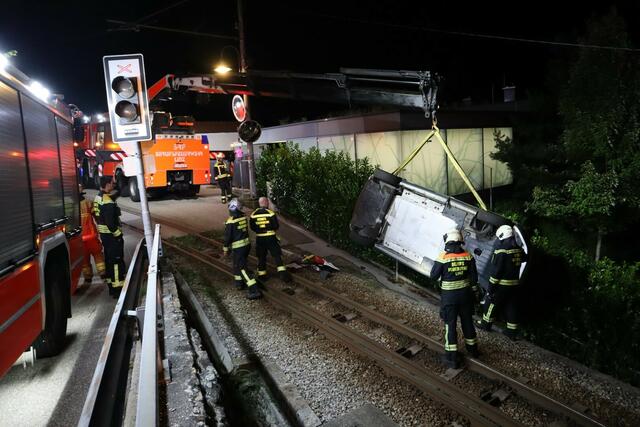 Mit einem Kran hob die Berufsfeuerwehr das Elektroauto zurück auf die Straße. | Foto: Berufsfeuerwehr Linz