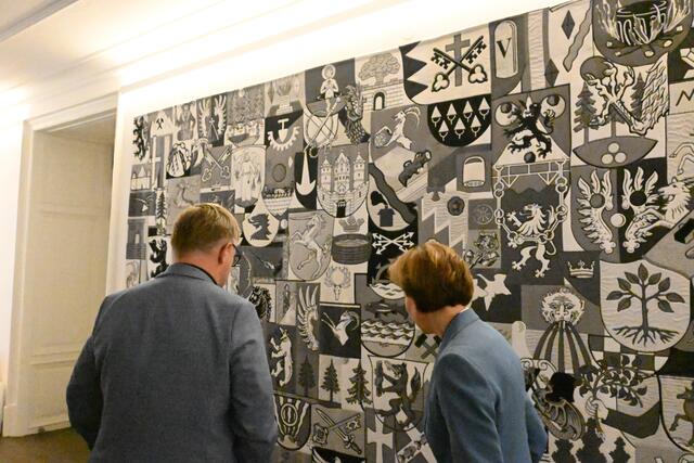 R.I.E.S.I.G. die Künstlerin Michaela Melián hat den Wandteppich im Chiemseehof gestaltet Im Bild(v.l.) Christian Braunstein (Vizebürgermeister von Fuschl): Landtagspräsidentin Brigitta Pallauf suchen nach den Ortswappen.