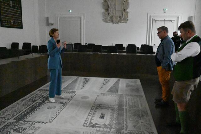 Die Landtagspräsidentin Brigitte Pallauf erklärt auch die kulturellen Sehenswürdigkeiten im Landesparlament, wie den Teppich mit seiner geschichtlichen Symbolik. | Foto: Martin Schöndorfer, 2023