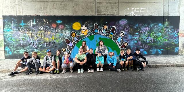 Denise Dick vom Jugendtreff mit den teilnehmenden Kindern und dem Graffiti Künstler „sert73“. | Foto: Gemeinde Bruck