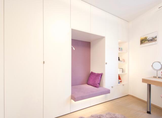 Eine farblich abgesetzte Leseecke lässt den Wandschrank, mit viel Stauraum, weniger massiv wirken. | Foto: FRAME OG