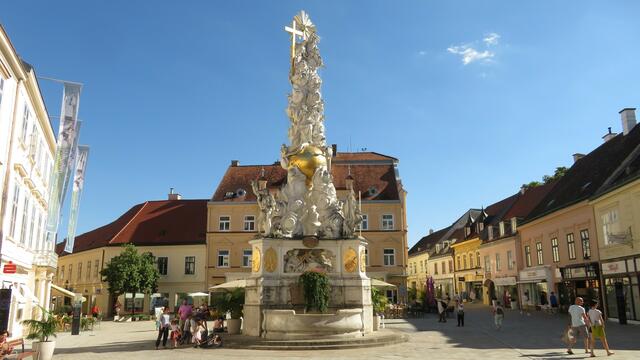 11.08.2023 die Dreifaltigkeitssäule im Zentrum von Baden mit Brunnen